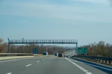Toll enforcement cameras on the D2 motorway in the Czech Republic heading towards Bratislava and the Slovak border, with distance sign showing Kúty 18 km and Státní hranice 12 km